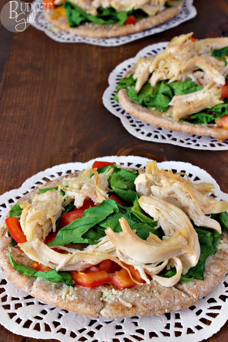 Pita Pocket Pizza --- Pita pizza is a healthier Greek-inspired pizza made using pita pockets, fresh vegetables, and meats. || via diybudgetgirl.com #pizza #tomatoes #spinach #chicken #pita #individual #smallportions