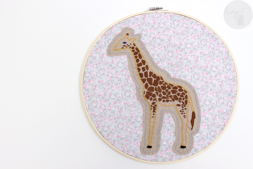 This giraffe embroidery is an adorable way to add some charm to a room. Change out the colors and fabrics to make it fit any style! || via diybudgetgirl.com #giraffe #embroidery #sewing #crafts #diy #fabric